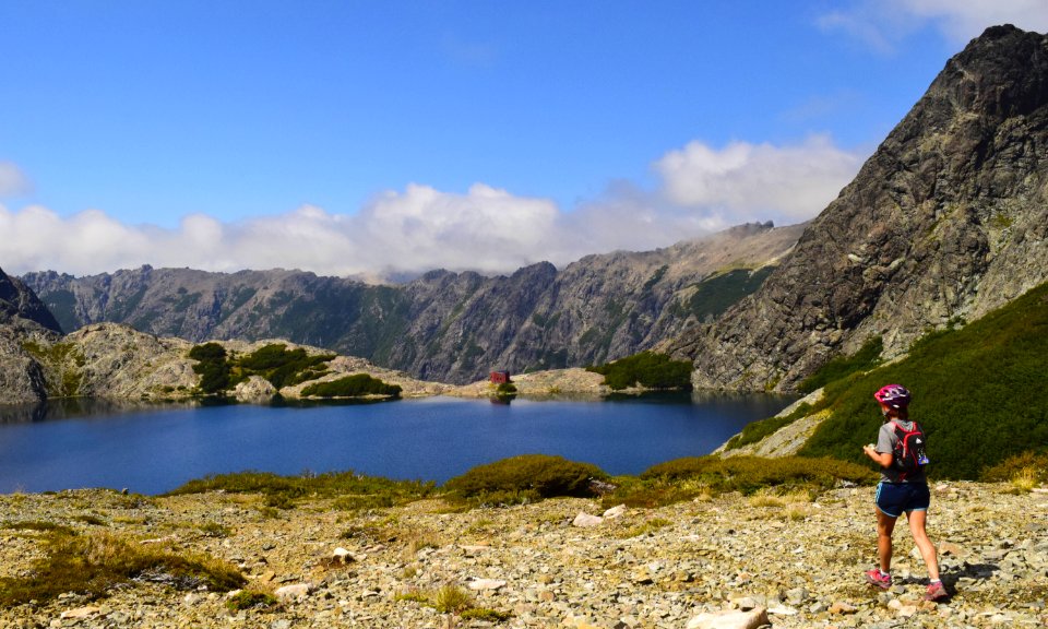Person Standing Near Lake Under Cloudy Sky