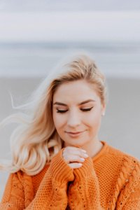 Blonde Haired Woman In Orange Knitted Long-sleeved Top photo