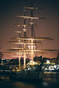 White And Brown Boat With Light Near Buildings At Night
