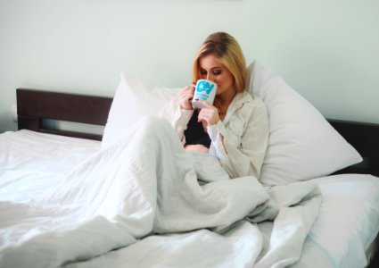 Woman Sitting On Bed Holding Mug photo