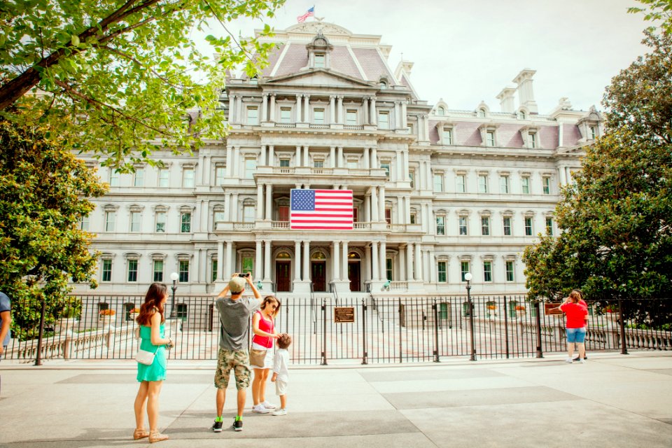 Photo Of Group Of People Near White Concrete Building White Flag Of Usa