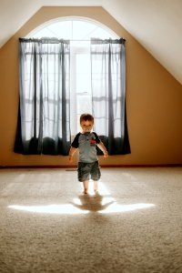 Boy Wearing Gray T-shirt And Gray Cargo Shorts Inside White Painted Wall Room photo