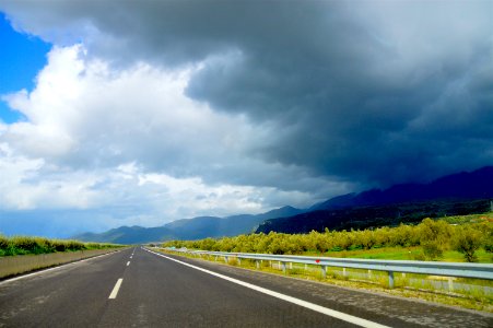 Photo Of Road Near Green Leaf Trees Under Dark Clouds At Daytime photo