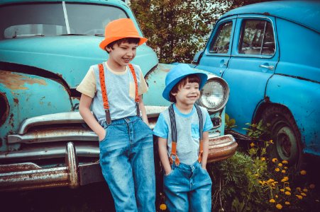 Two Boys Leaning On Classic Teal Vehicle photo