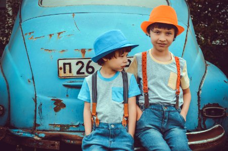 Two Boys Sitting On Blue Volkswagen Beetle Coupes Rear Bumper photo