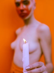 Shallow Focus Photography Of Topless Woman Holding White Candle photo