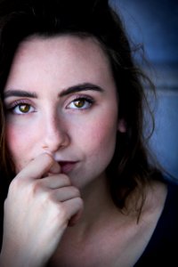 Closeup Photo Of Woman In Black Top With Her Index Finger On Top Of Her Lower Lip