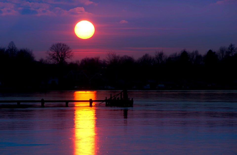 Boat Dock On Body Of Water During Golden Hour