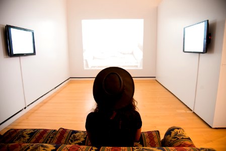 Woman Sitting On Red-and-green Suede Sofa Facing Well Lighted Room