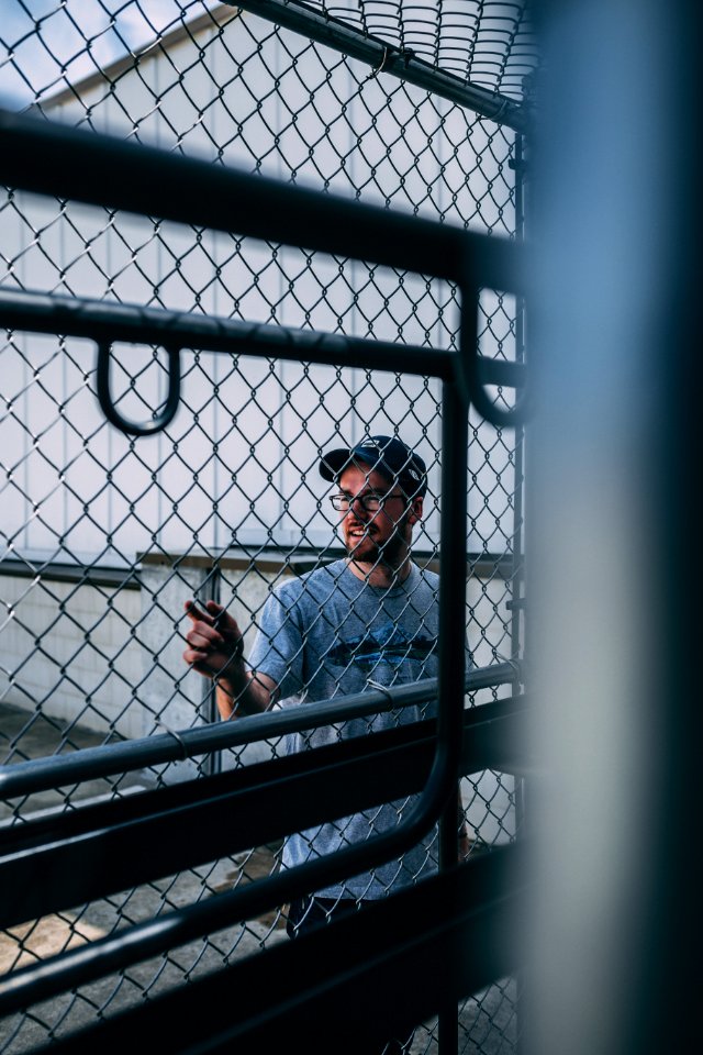 Man In Gray Steel Cyclone Fence