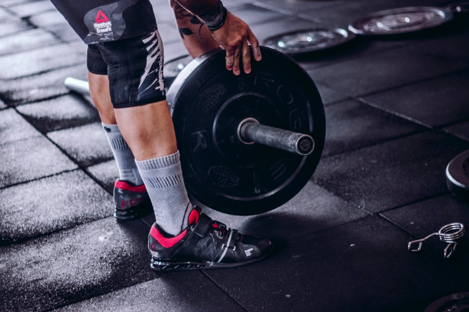 Man Picks Up Black And Grey Barbell
