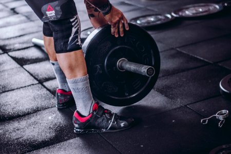 Man Picks Up Black And Grey Barbell