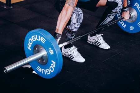 Man With Lift Stance Holds Blue Rogue Adjustable Barbell photo
