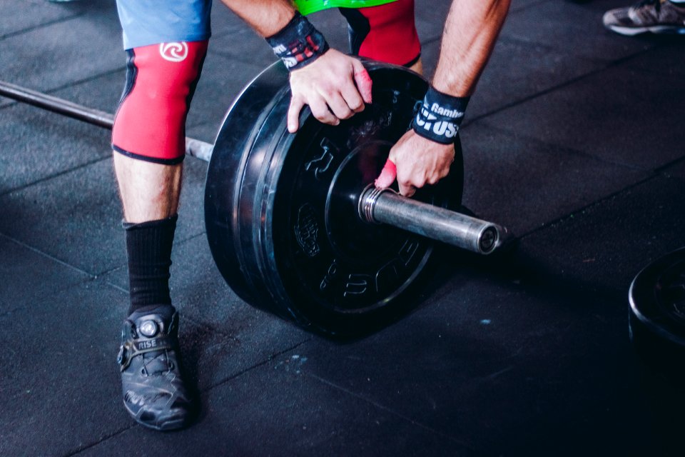Person Holding Black Bumper Plate
