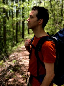 Man In Red Crew-neck Shirt Carrying Blue Hiking Backpack photo