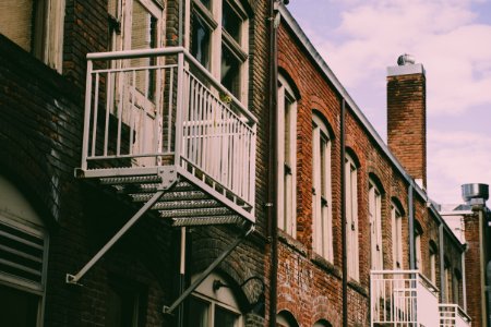 Closeup Photo Of Brown Building With Fire Exit Ladder photo