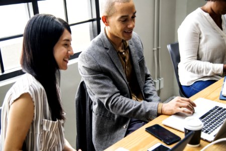 Photo Of Man And Woman Looking At Laptop