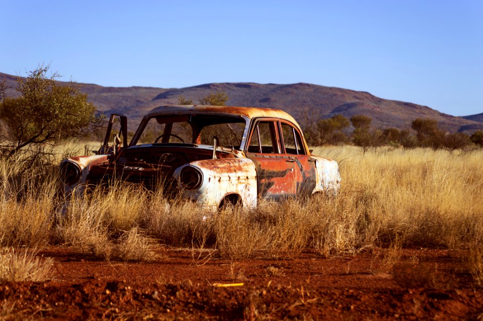 Photo Of Corroded Vintage White And Red Sedan On Brown Grass