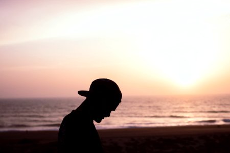 Silhouette Of Man Wearing Cap At The Beach photo
