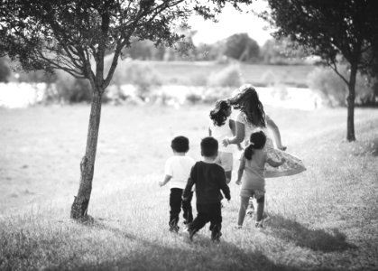 Grayscale Photo Of Five Children Near Tree photo
