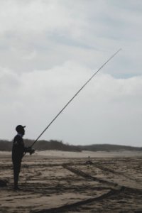 Man Standing Holding A Fishing Rod photo