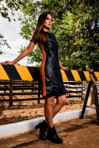 Woman Wearing Black And Brown Leather Midi Dress And Black Chunky Heeled Boots photo