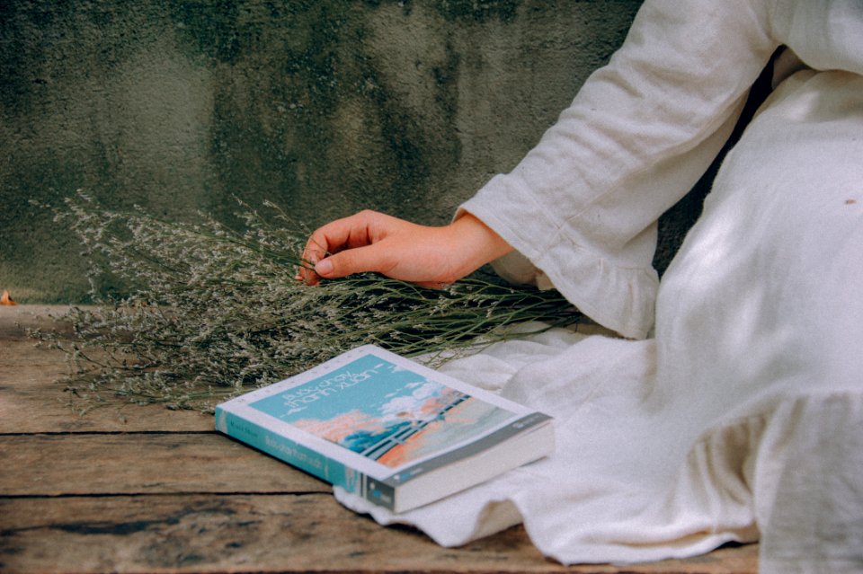 Blue And White Book Beside Woman Wearing White Dress