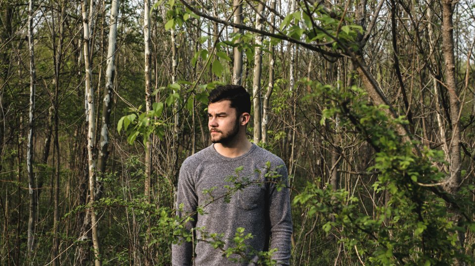 Man In Gray Crew-neck Long-sleeved Shirt Standing Near Plants photo