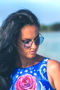 Shallow Focus Photography Of Woman Wearing Blue Floral Sleeveless Top And Black Sunglasses With Gray Frames photo