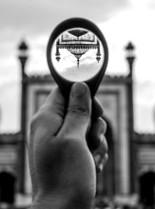 Grayscale Photo Of Person Holding Round Magnifying Glass photo