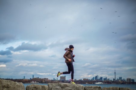 Woman Standing On Stone Near Body Of Water