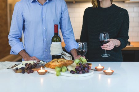 Man Standing Beside Woman In Front Of White Wooden Dining Table photo