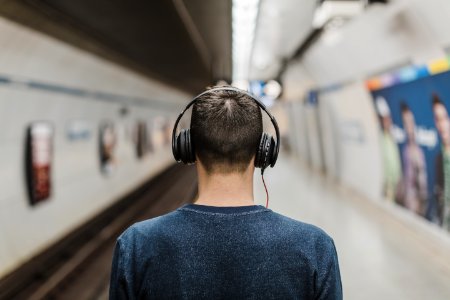 Man Wearing Black Headphones Beside Train Rail photo