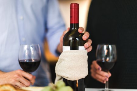 Man Holding White Labeled Red Wine Bottle Near Wine Glasses photo