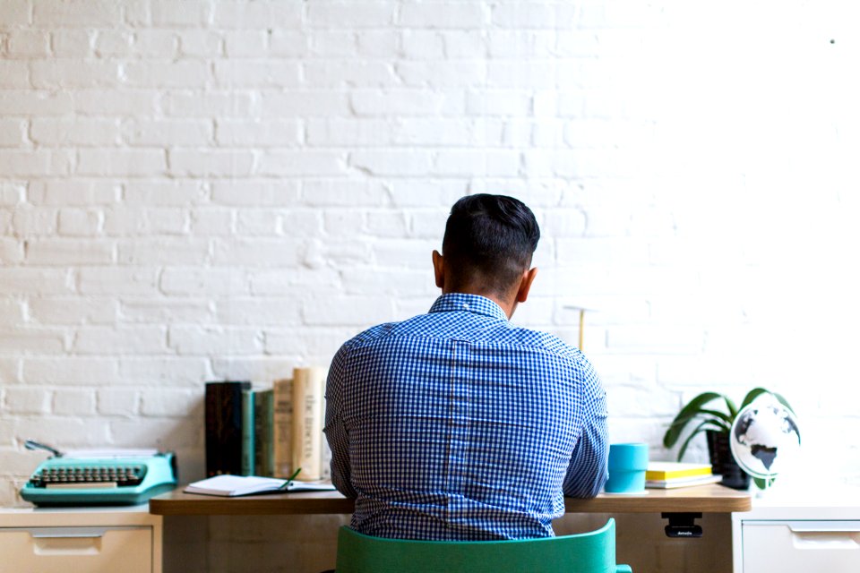 Man Sitting On Chair Facing Table