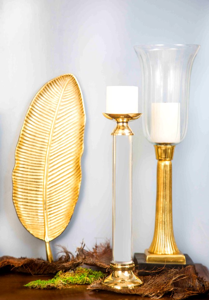 Two White Pillar Candles And Two Gold-colored Candlesticks