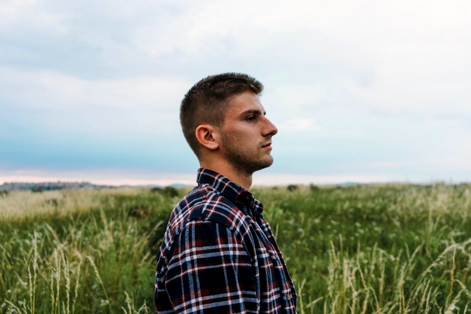 Man Standing On Grass Field
