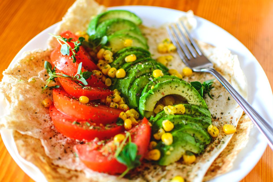 Sliced Tomato And Avocado On White Plate