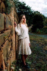 Photo Of Woman In White Long-sleeved Shirt Beside Concrete Wall photo