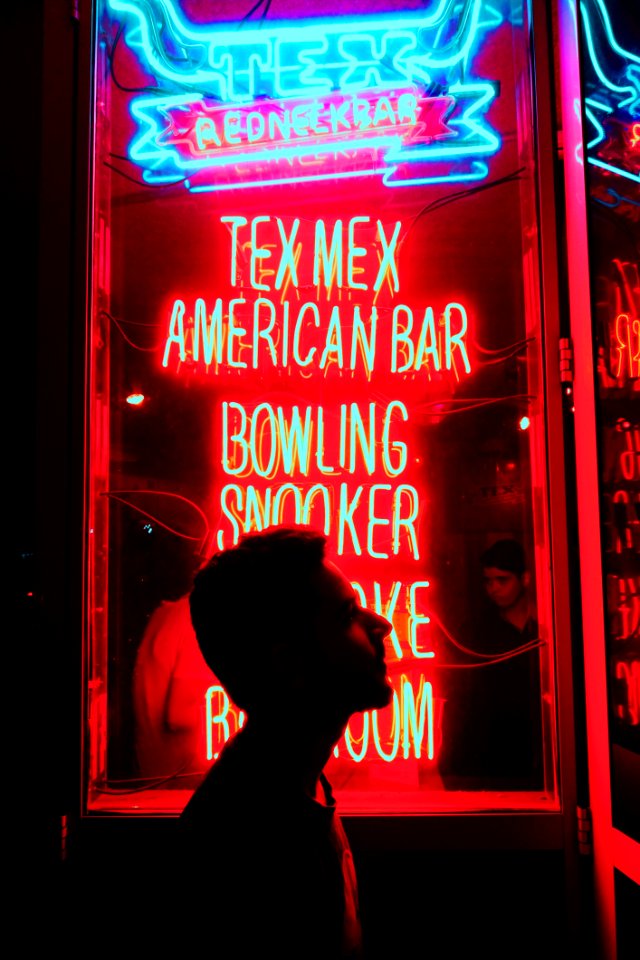 Silhouette Of Man In Front Of Red And Blue Led Light Signage