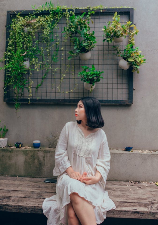 Woman In White V-neck Long-sleeved Dress Sitting On Bench photo