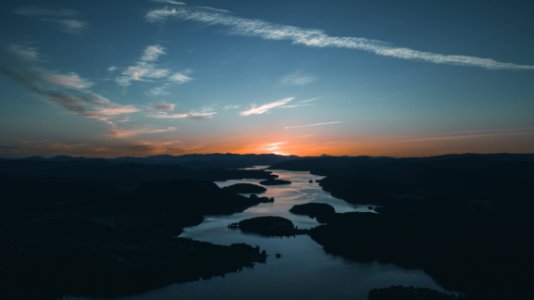 Aerial Photography Of Water Beside Forest During Golden Hour photo