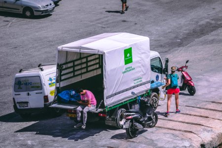 Man In Pink Shirt Sitting At The Back Of White Truck