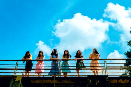 Six Women Wearing Mini Dresses Leaning On Bridges Rail
