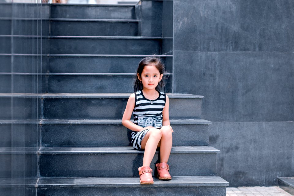 Girl Wearing Black And White Striped Dress Sitting On Stair