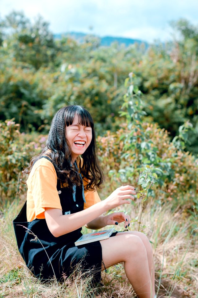 Woman Wearing Black Romper Sitting On Grass