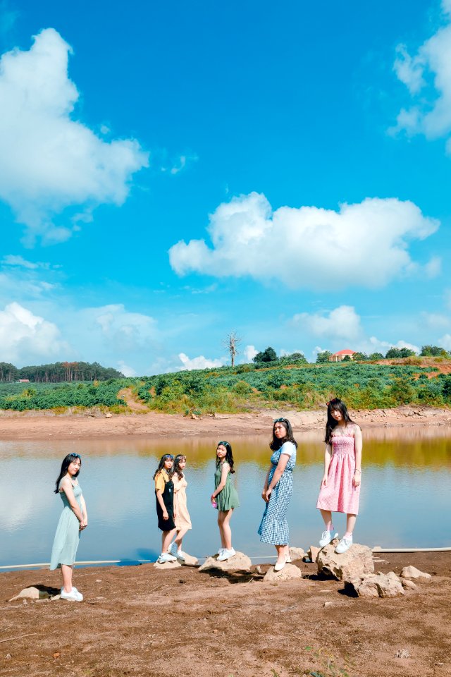 Group Of Women Standing Besides Body Of Water photo