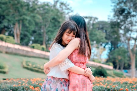 Candid Photography Of Two Female Hugging photo