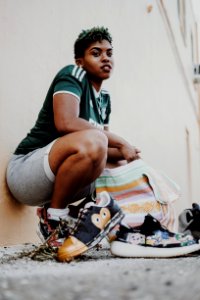 Woman Squatting And Leaning Against Wall