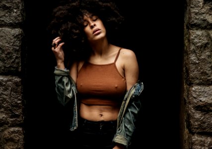 Woman In Brown Crop Top Standing Between Concrete Walls photo